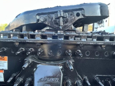 Truck drivetrain showing chain drive and bolted components on a Freightliner Cascadia 126 chassis with visible bolts and frame details.