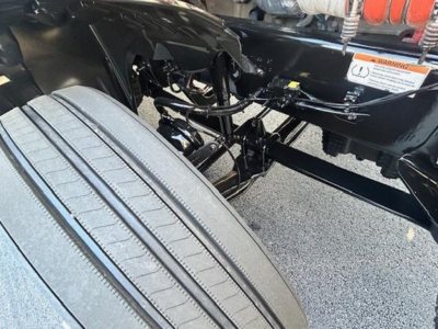Freightliner Cascadia 126 chassis and front suspension visible with tire and undercarriage components.