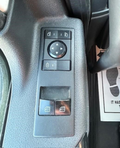 Freightliner Cascadia 126 interior window/door control panel close-up showing mirror adjustment joystick and window switchs.