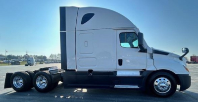 Freightliner Cascadia 126 sleeper tractor in profile view showing side of cab and rear wheels.