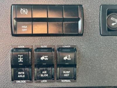 Dashboard controls showing HSA OFF switch and multiple locking/slide switches in Freightliner Cascadia cab.