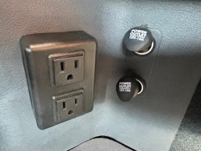 Freightliner Cascadia interior showing two power outlets labeled 12V 10A and a dual electrical outlet with a 120V receptacle panel.