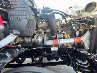 Engine bay of a Freightliner Cascadia showing intake, turbo piping, and coolant hoses with red-orange silicone couplers.