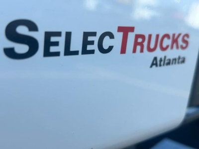 Branding on a truck showing 'SELECT TRUCKS' with Atlanta text partially visible, white surface with black and red letters.