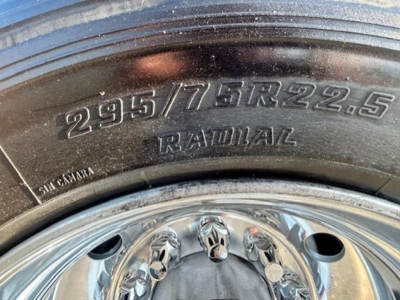 Tire and wheel close-up showing 295/75R22.5 radial tire on a polished chrome wheel.