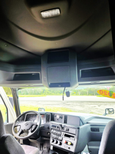 Interior cab view of a 2020 International CONDO DOUBLE BUNK conventional sleeper truck showing dashboard, steering wheel, overhead console, and front seats.