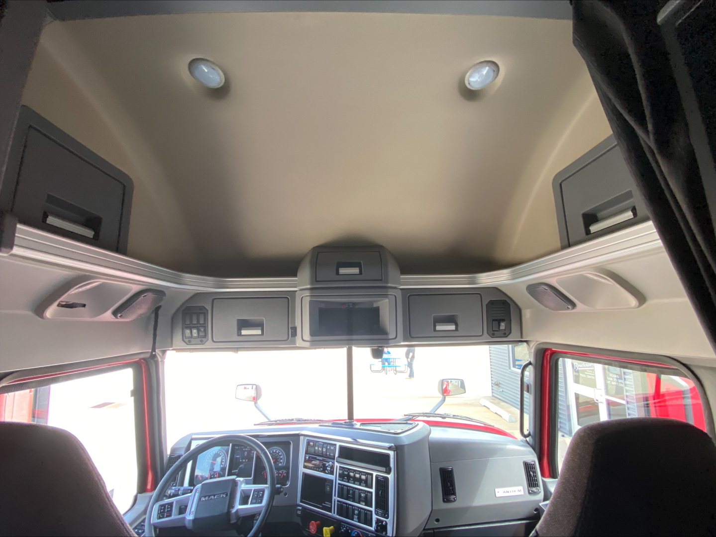 Cab interior of a 2020 Mack AN64T70 sleeper truck with overhead storage and dashboard visible