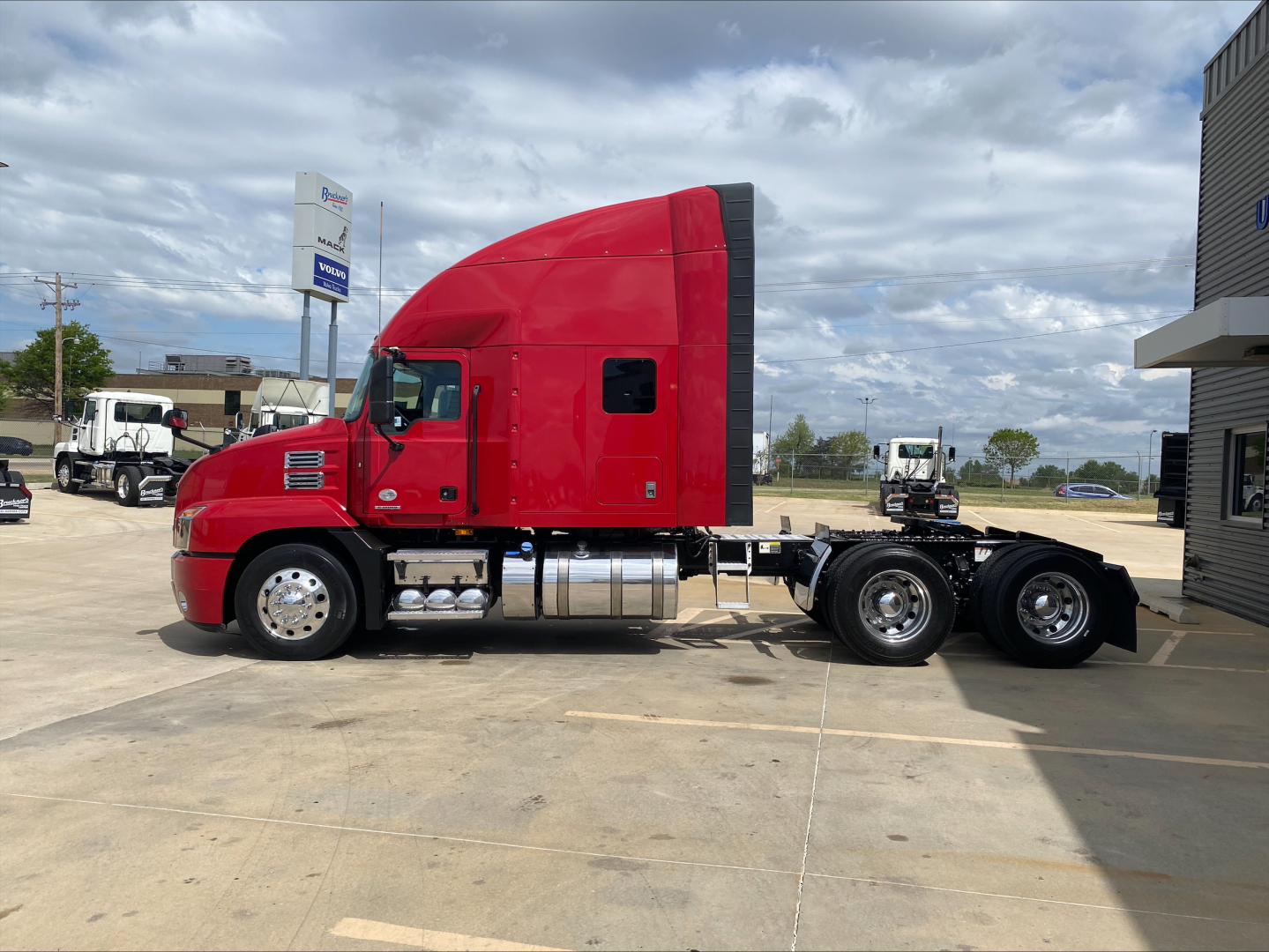 Red Mack AN64T70 sleeper tractor side profile showing cab, fuel tanks, and chassis without trailer.