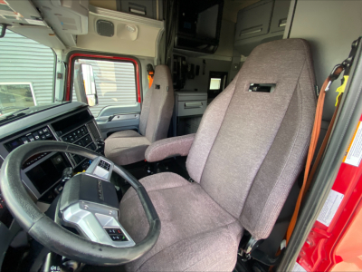 Cab interior of a 2020 Mack AN64T70 truck showing steering wheel and driver seat with gray fabric seats and dashboard controls.