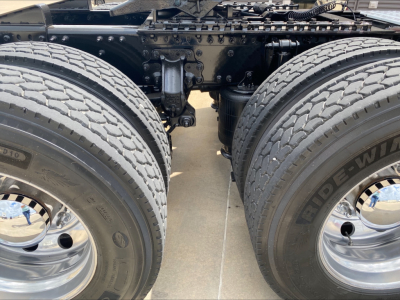 Mack AN64T70 truck rear view showing dual rear axles with large tires and chrome rims, chassis frame and suspension components visible between wheels.