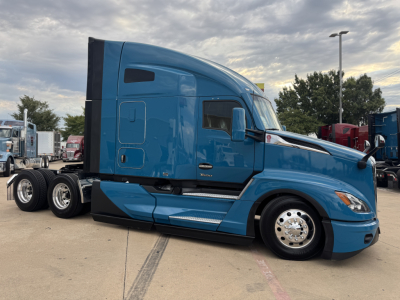 Kenworth T680 tractor in blue, side view showing driver cab and sleeper with chrome fuel tanks, wheels, and mirrors.