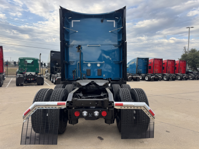 Rear view of a blue Kenworth T680 truck tractor, dual rear axles, with mud flaps and fifth-wheel area visible.