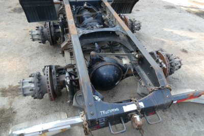 Truck chassis rear view showing drive axles and suspension for a Volvo VNM64T cab and chassis.