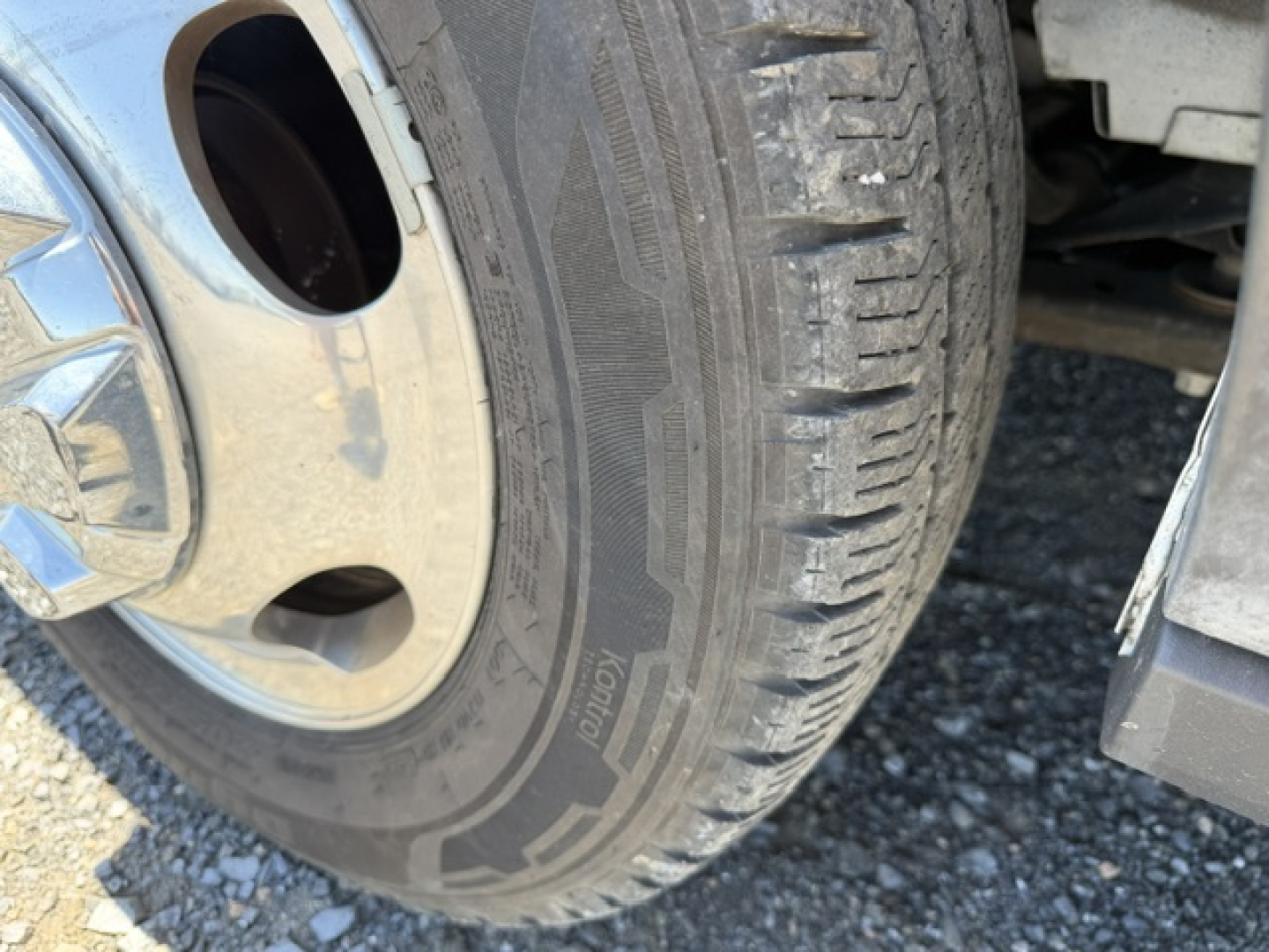 Truck wheel and tire close-up showing Michelin X tires and wheel well on a Ford Transit 350HD cargo van.