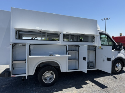 Ford Transit 350HD service utility truck side view with white utility body open compartments and storage shelves.