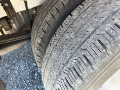 Ford Transit 350HD wheel and tire from a service/utility truck showing tread detail and front axle area.