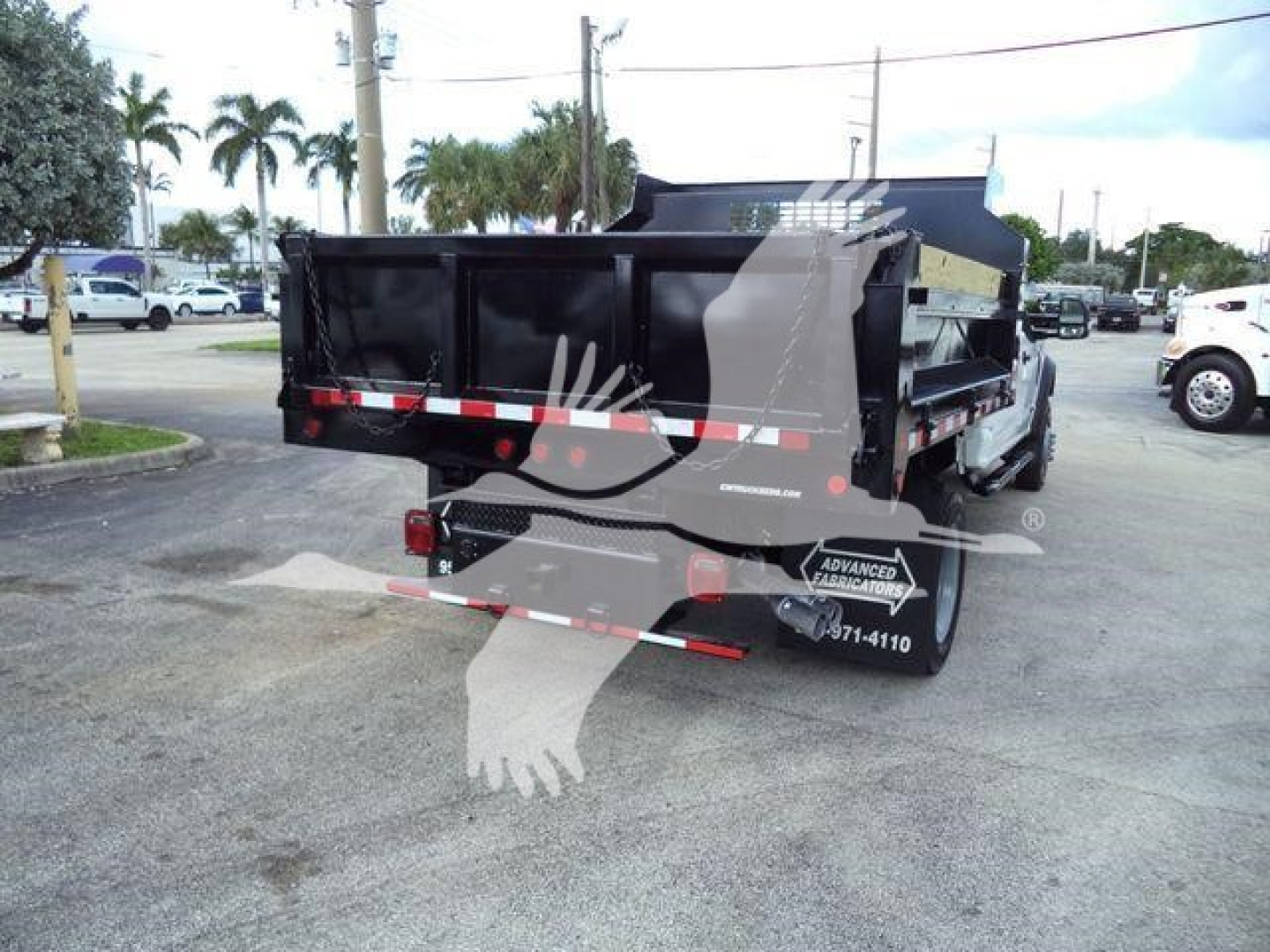 Dump truck bed of a 2018 Ford F550 XL in service showing black dump body with reflective tape and rear lights.