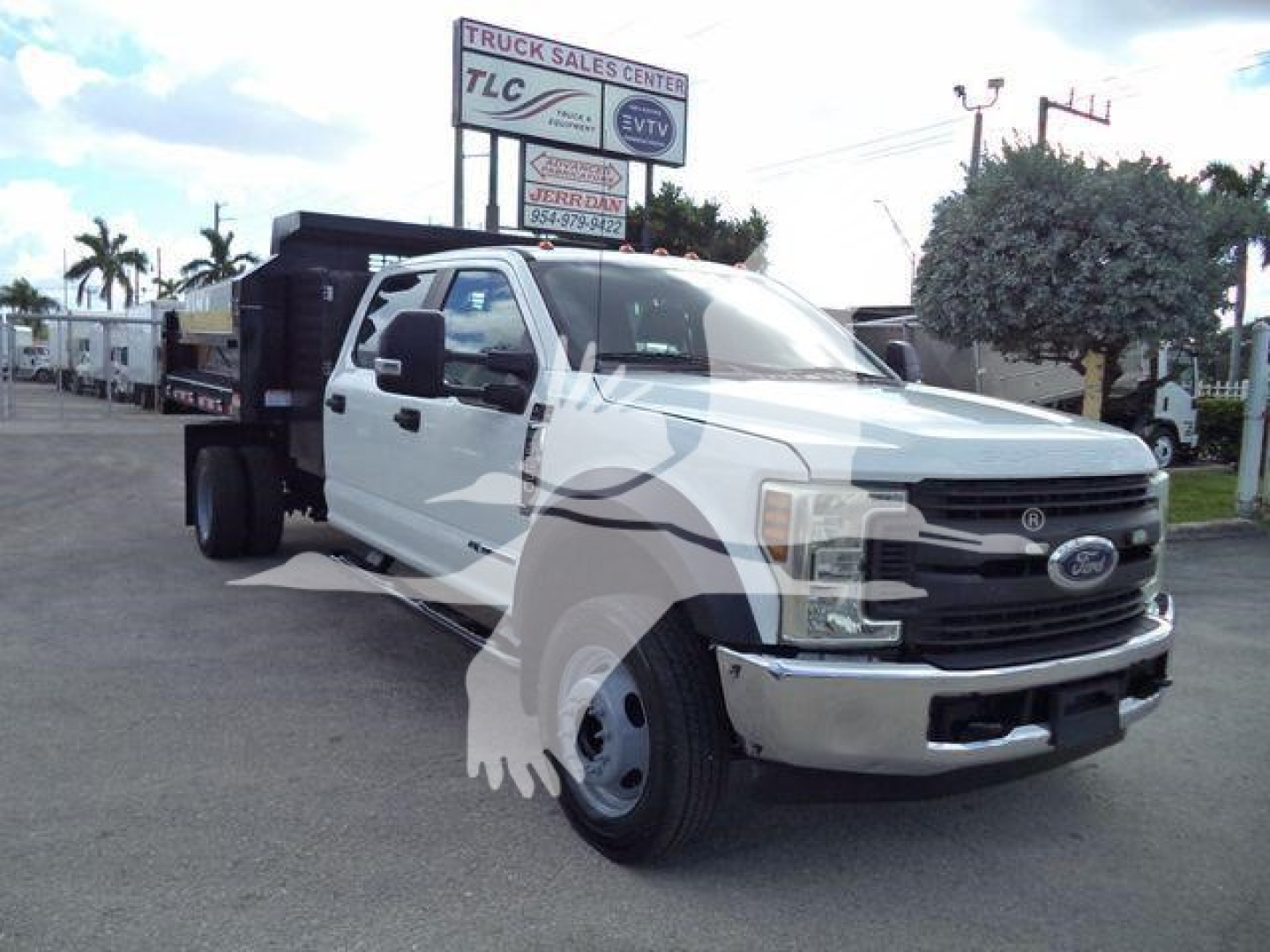 Ford F-550 dump truck shown front-left view with white cab, black grille, and dump bed in background.