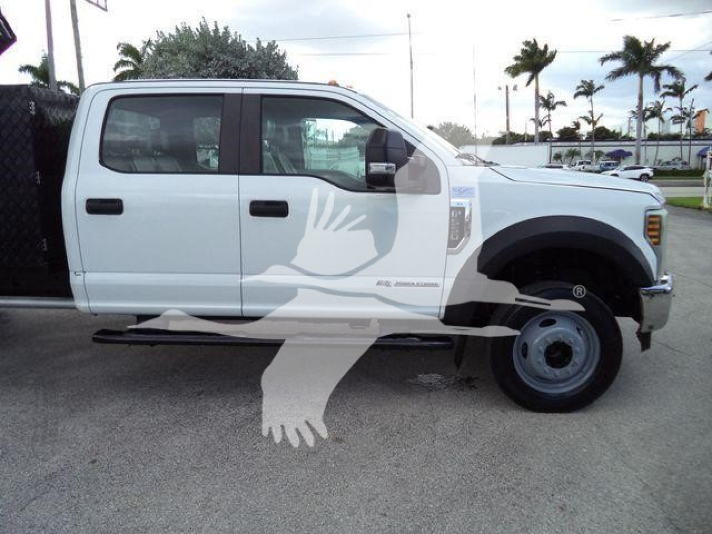 Ford F-550 dump truck side view showing crew cab white exterior, dual rear wheels, and front fender with 'F-550' badge.
