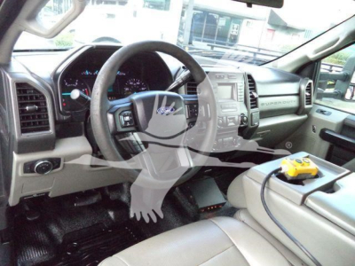 Dashboard and steering wheel of a 2018 Ford F-550 Dump truck interior with center console, dashboard controls, and a yellow digital multimeter on the seat.