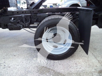 Ford F-550 chassis side view showing front wheel and suspension with black frame and wheel well, partial cab off, no cab details visible.