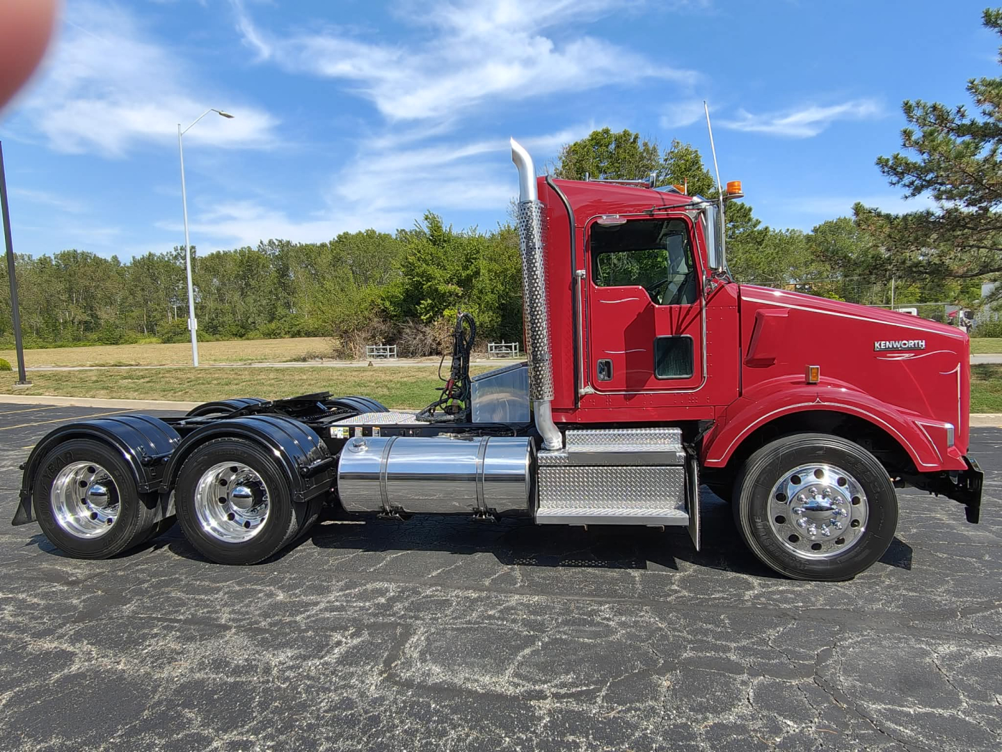 Kenworth T800 conventional daycab truck in red with chrome fuel tanks and dual rear axles.