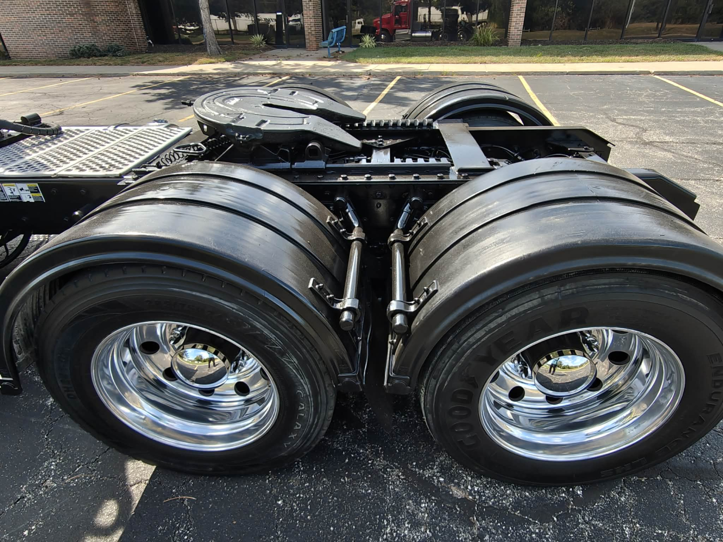Dual rear tractor axles and fifth wheel on a Kenworth T800 cab chassis showing polished chrome wheels and heavy-duty tires.
