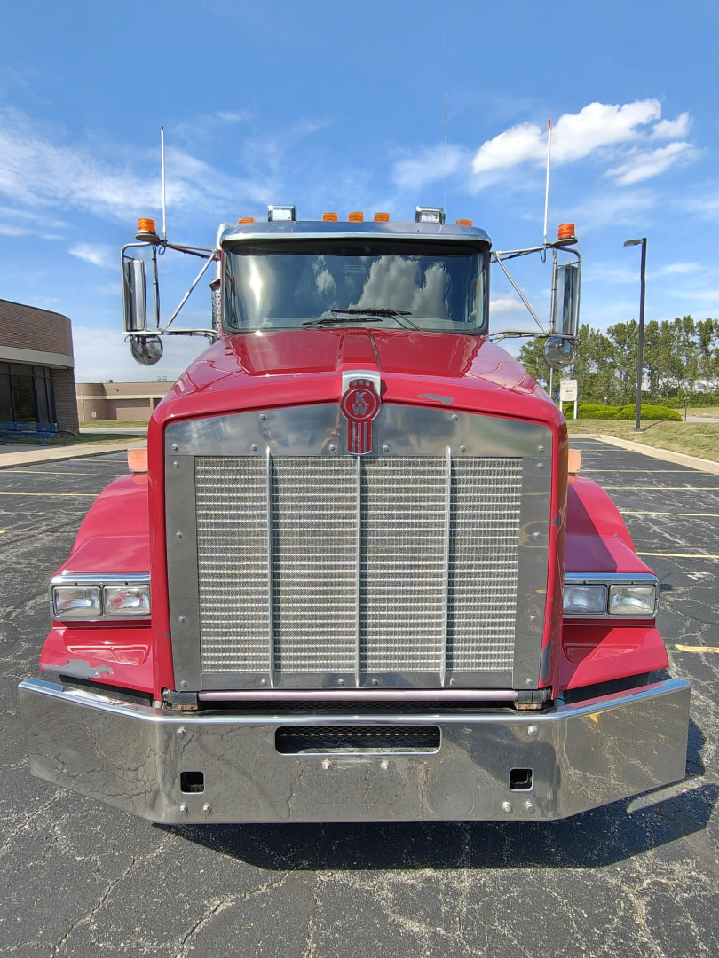 Kenworth T800 conventional daycab front view showing large chrome grille and bumper, headlights, and marker lights.