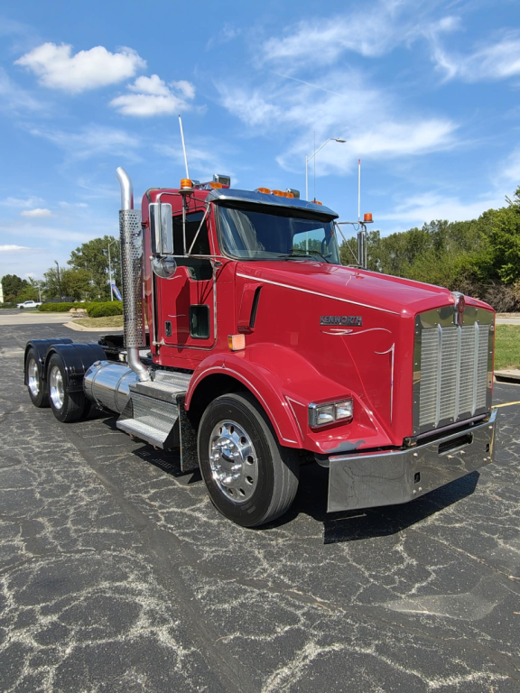 Kenworth T800 conventional daycab truck with red exterior, chrome bumper, and side exhaust stacks.