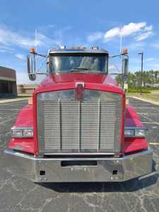 Kenworth T800 conventional daycab front view showing large chrome grille and bumper, headlights, and marker lights.