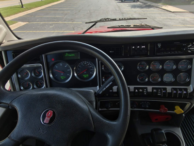 Kenworth T800 truck interior dashboard and steering wheel with multiple gauges and controls.