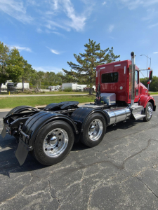 Kenworth T800 rear and cab view showing dual rear axles and chrome fuel tanks; no visible text legible on components.