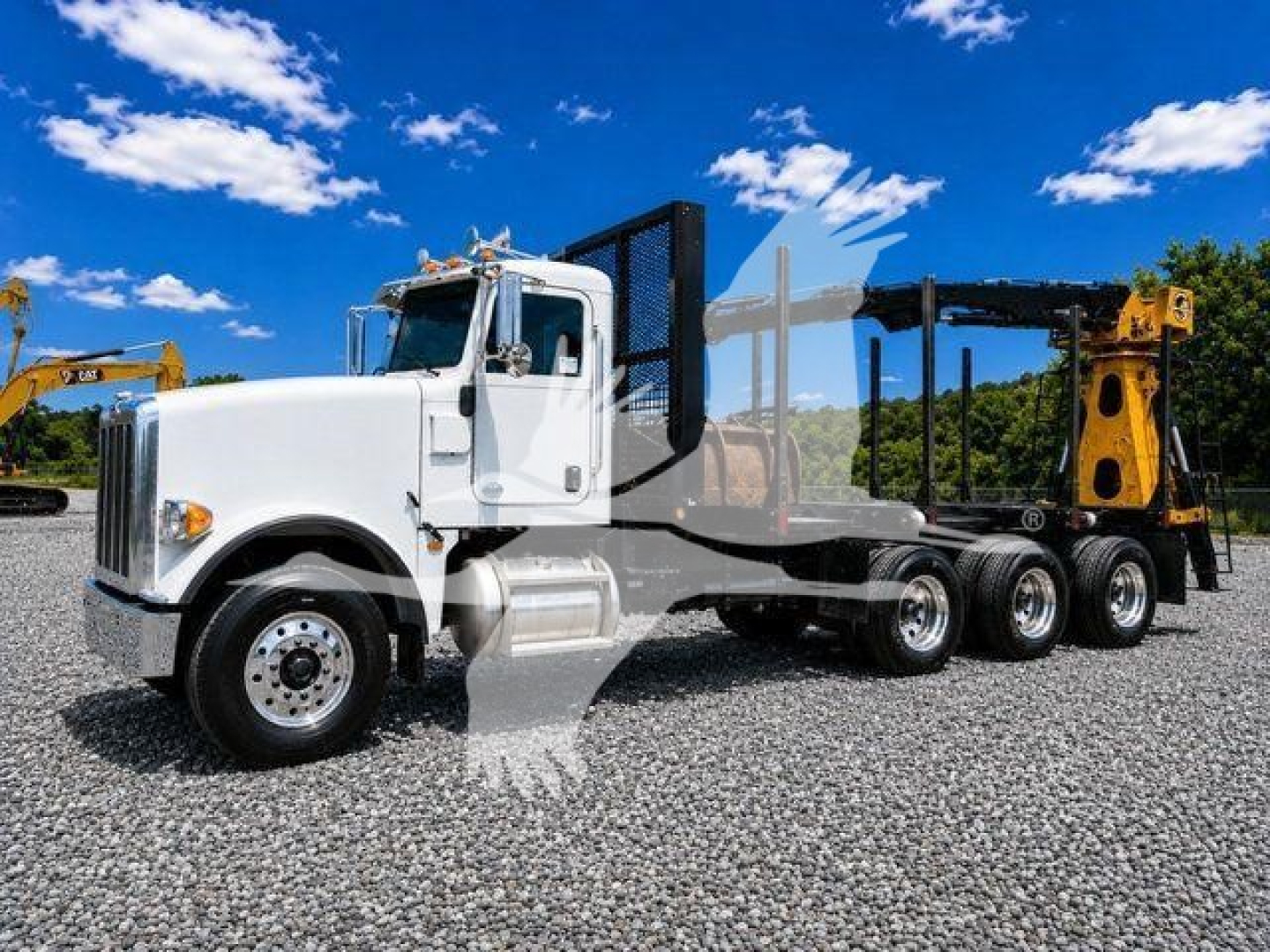 2016 Peterbilt 367 semi-tractor with white cab and black grapple trailer, side view showing triple rear axles and heavy-duty equipment in background.
