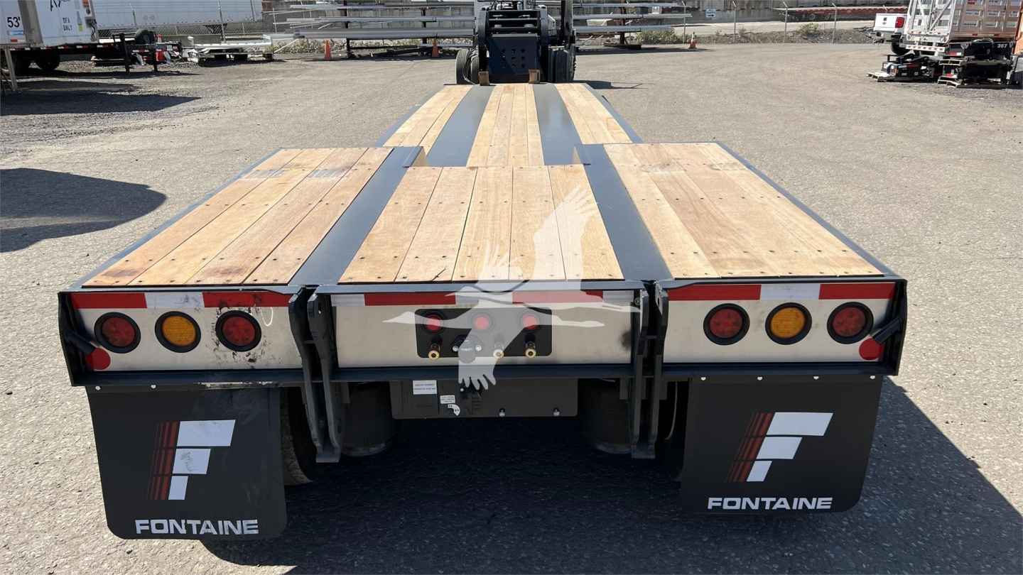 Flatbed trailer rear view showing Fontaine branding and taillights, wooden deck with metal supports.
