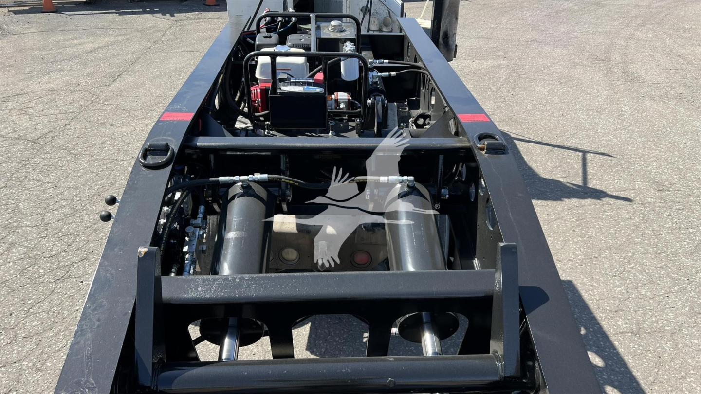 Trailer chassis with engine components and hydraulic tanks visible on a Fontaine XN20 lowboy trailer, inline view of machinery and frame rails.