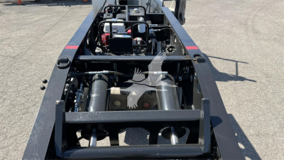 Trailer chassis with engine components and hydraulic tanks visible on a Fontaine XN20 lowboy trailer, inline view of machinery and frame rails.