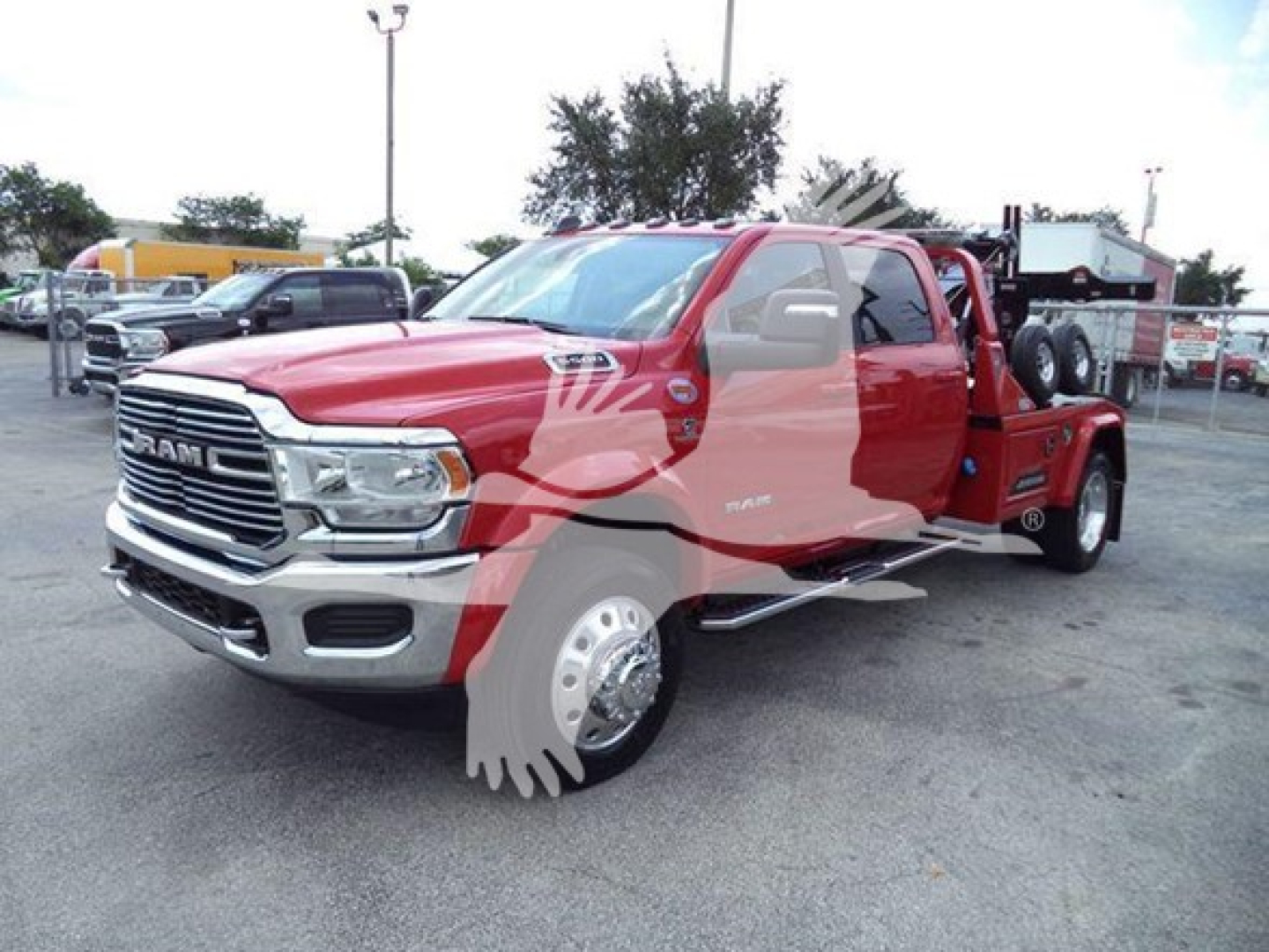 Ram truck in a dealership lot, red long-bed Ram 5500 style with chrome grille, dual rear wheels, and winch setup shown.