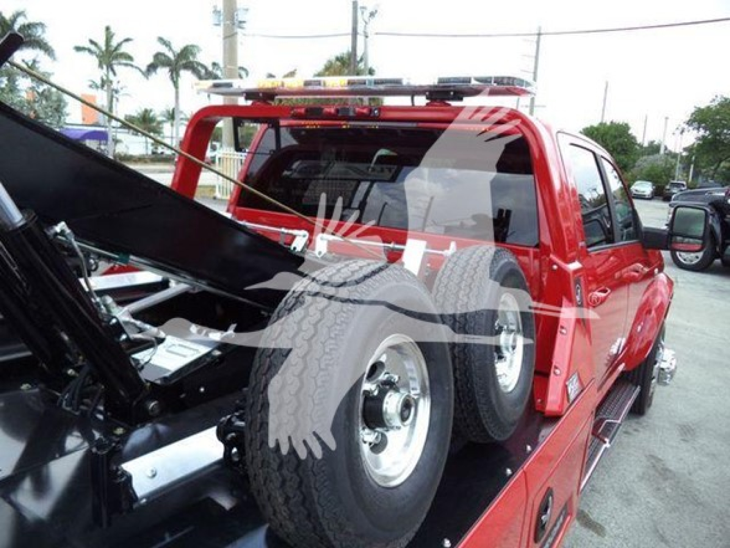 Ram pickup truck with open hood and spare tires in bed; visible text includes HAZARD stripe on a red winch-equipped truck and tires in bed