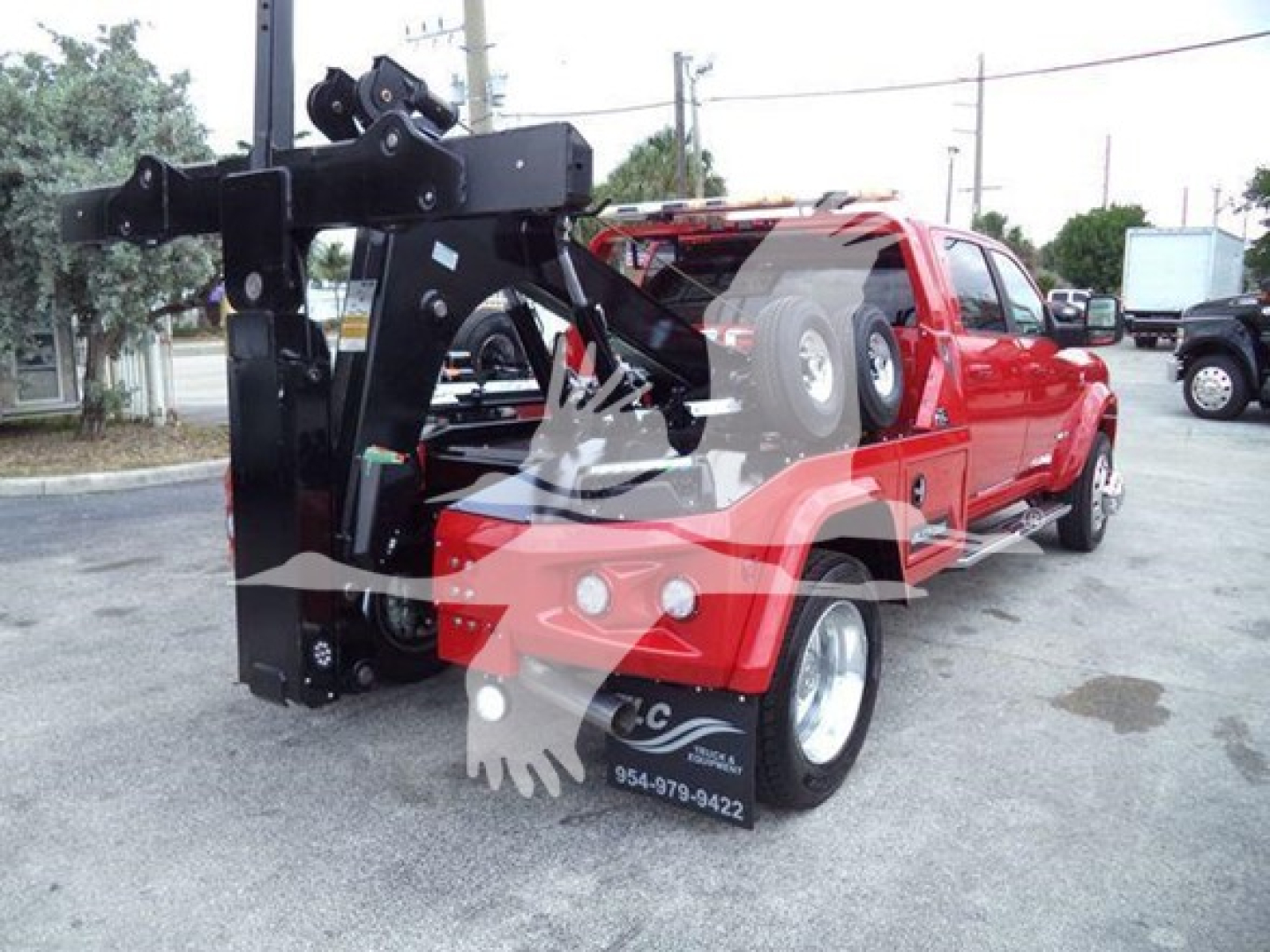 Truck bed with a mounted heavy-duty winch system and chassis components visible; rear cabin appears in red RAM pickup with winch apparatus attached.