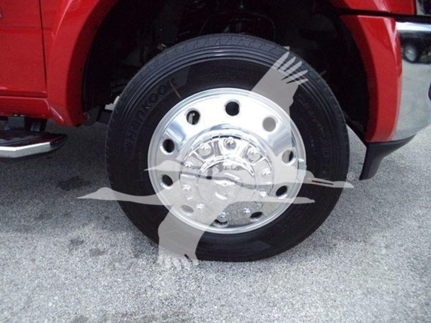 Wheel and tire close-up on a red Ram truck showing steel chrome hubcap and Goodyear tire branding.