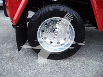 Wheel and tire close-up on a red Ram truck showing a polished aluminum rim with center cap and lug nuts, part of the front wheel assembly.