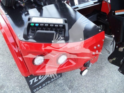 Front view of a red Ram truck winch setup showing control panel and bumper with two round headlights and a small hook, RAM branding not visible.