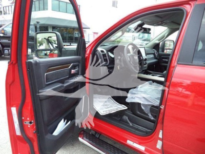 Ram pickup interior and open front door showing black leather panels and steering wheel; windshield; papers on seat; red exterior; stock photo watermark.
