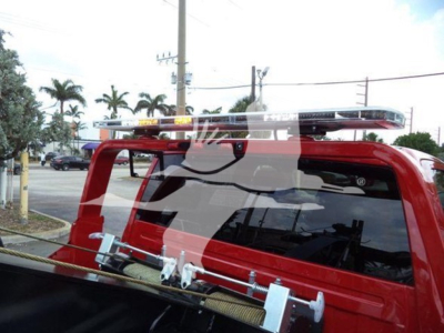 Ram pickup truck rear window with a roof-mounted light bar and winch hardware visible on truck bed; red body color; truck category: winch