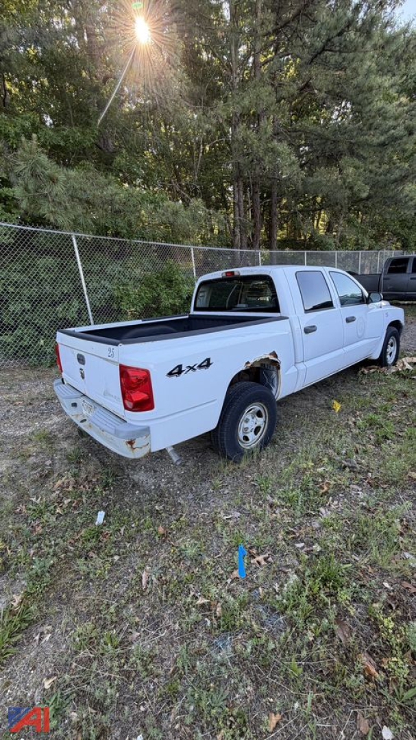 White 2006 Dodge Dakota pickup truck 4x4 rear view showing extended cab, bed cover, and alloy wheels; tailgate with Dodge emblem and 4x4 badge.