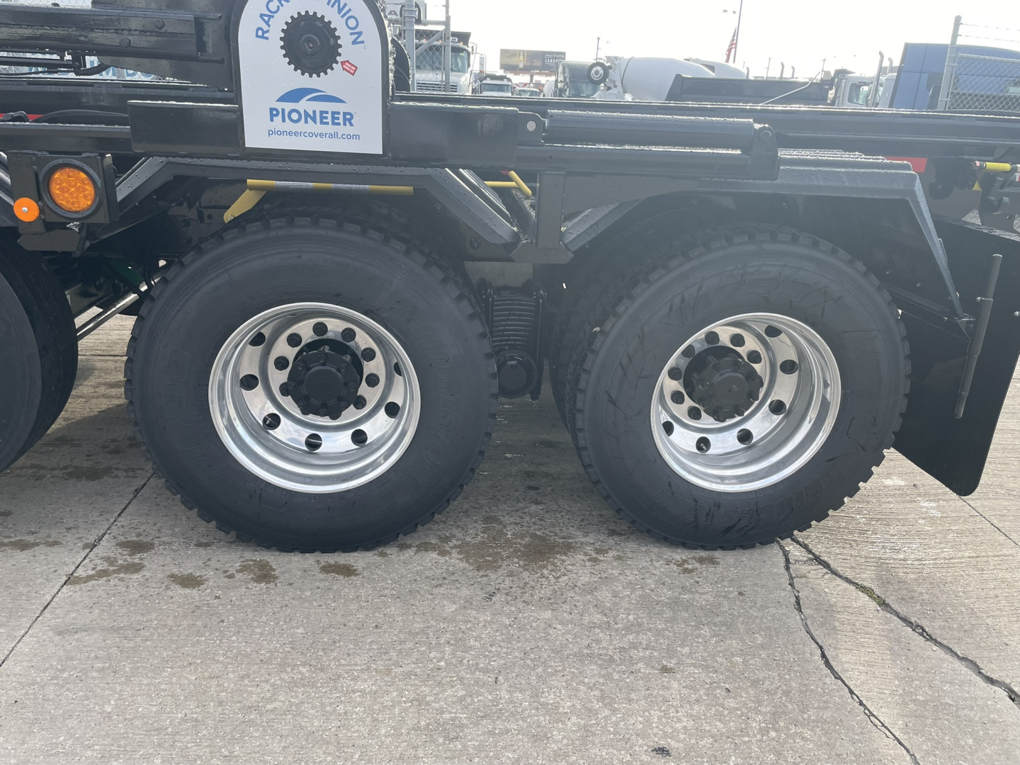 Mack GR64B rolloff truck dual rear axle wheels with large tires and chrome rims.