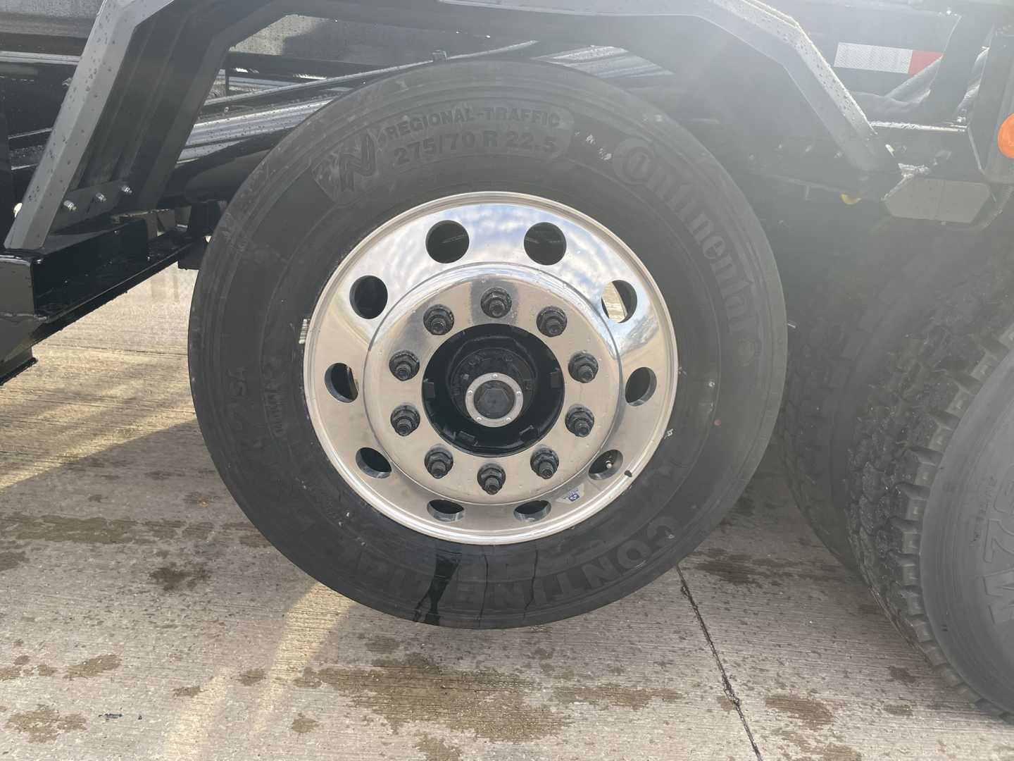 Wheel hub and tire on Mack GR64B rolloff truck showing Michelin XTA tire and polished aluminum wheel.