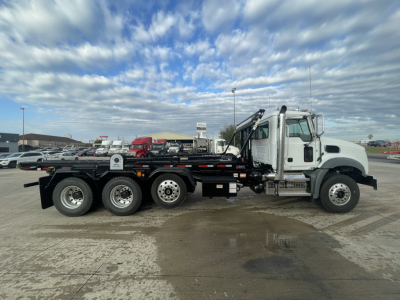 2026 Mack GR64B roll-off truck side view showing cab, hydraulic hooklift, and multiple rear axles.