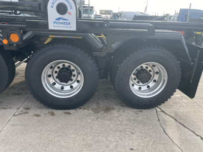 Mack GR64B rolloff truck dual rear axle wheels with large tires and chrome rims.