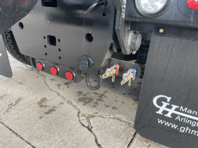 Mack GR64B truck rear showing hitch hooks and mudflaps with GH branding, red rear lights, and metal bumper plate.